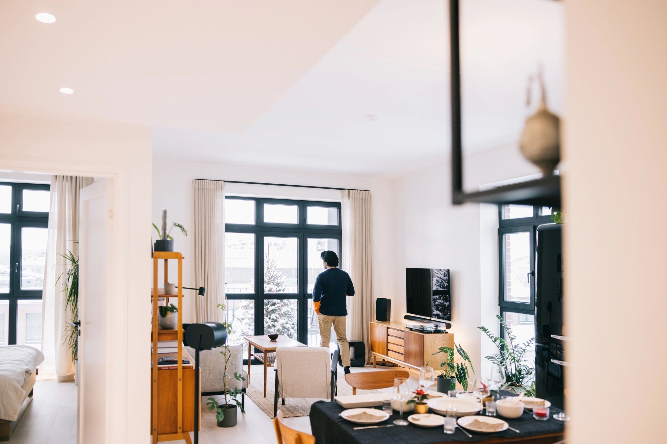 Host standing by a window in an apartment