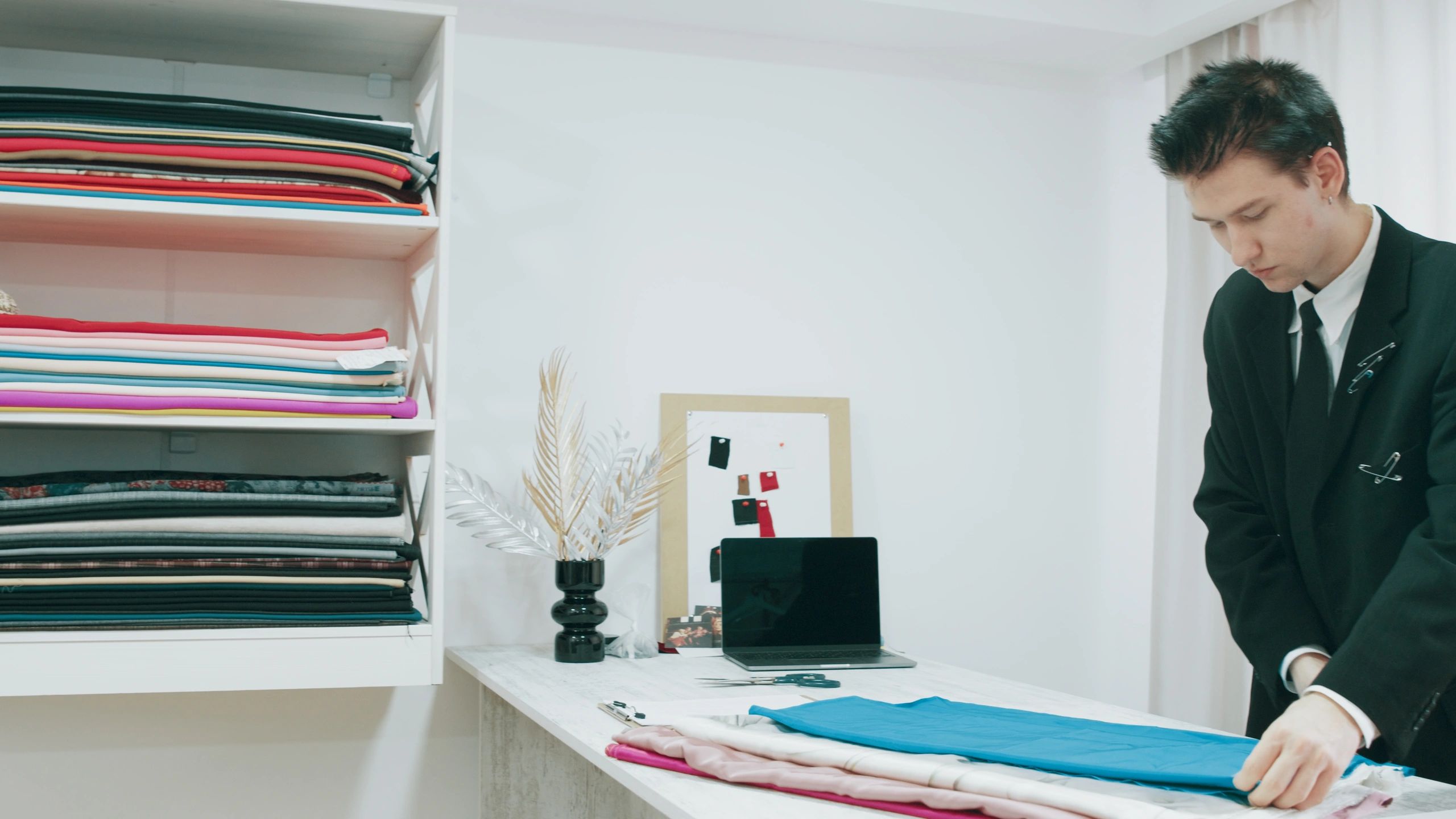 Designer working with fabric and materials on a worktable