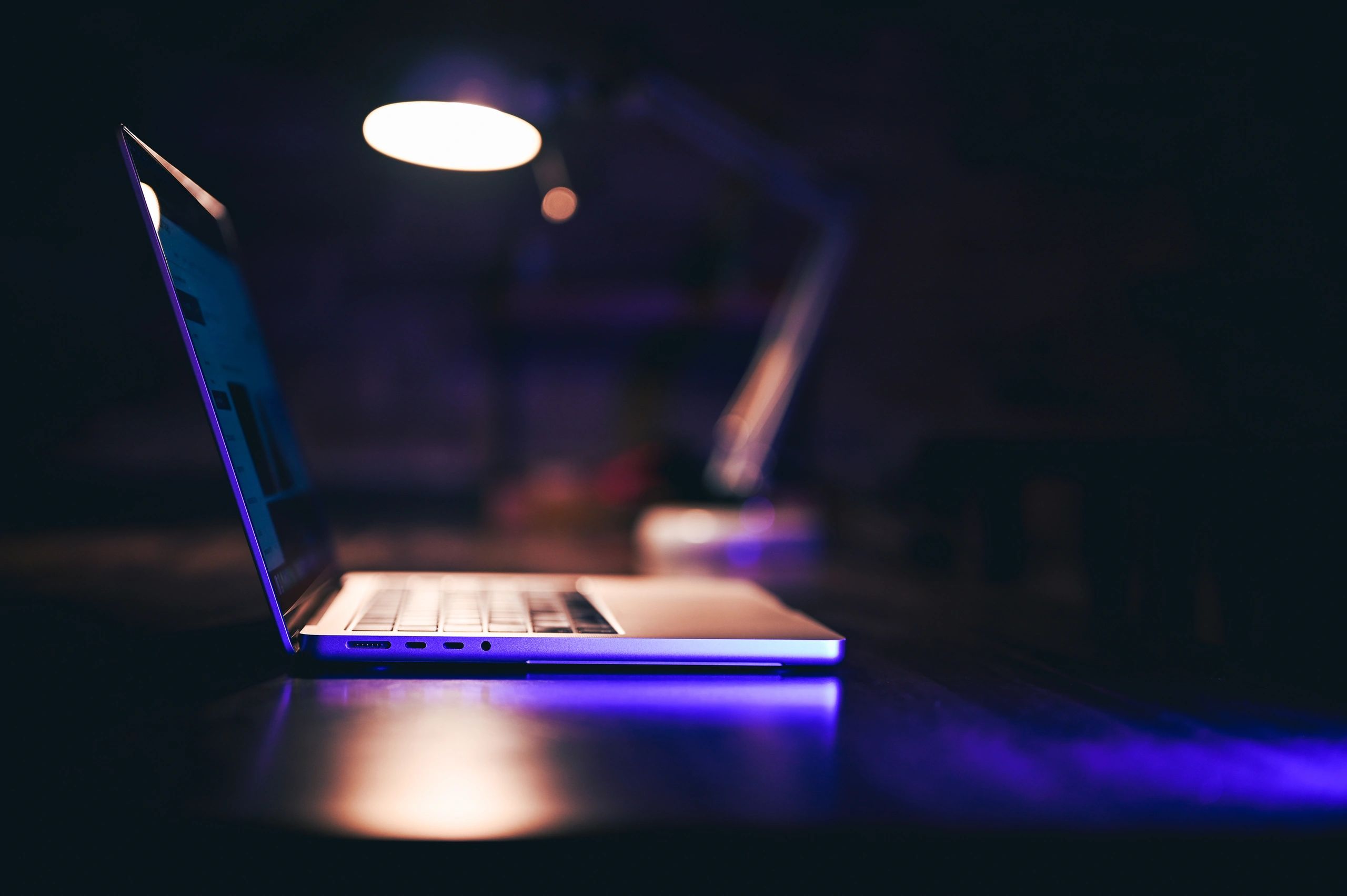 Laptop on a desk in low light representing data security